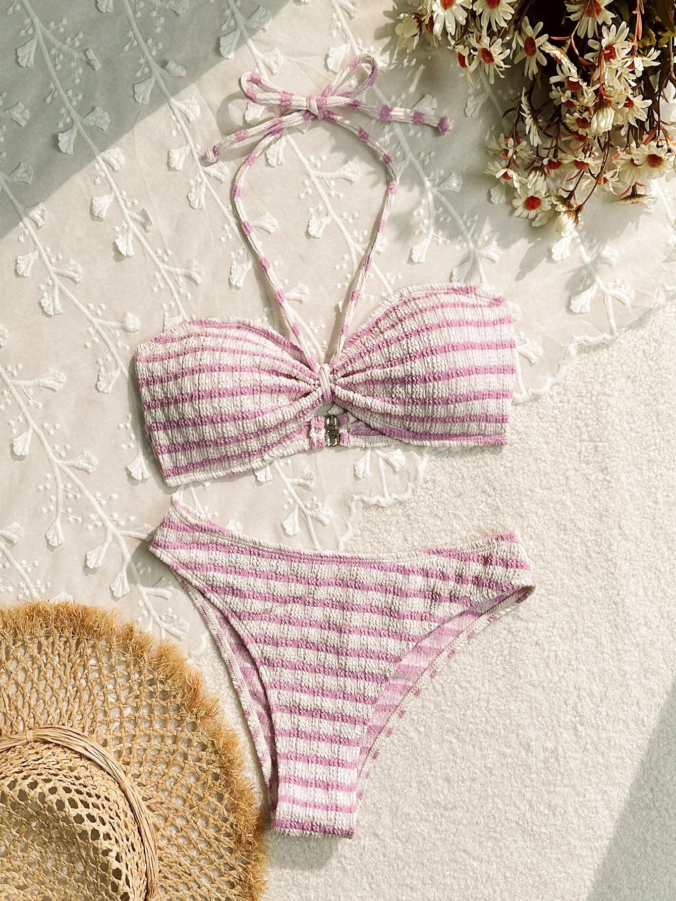 Women's pink and black striped printed bikini swimsuit on a hanger.