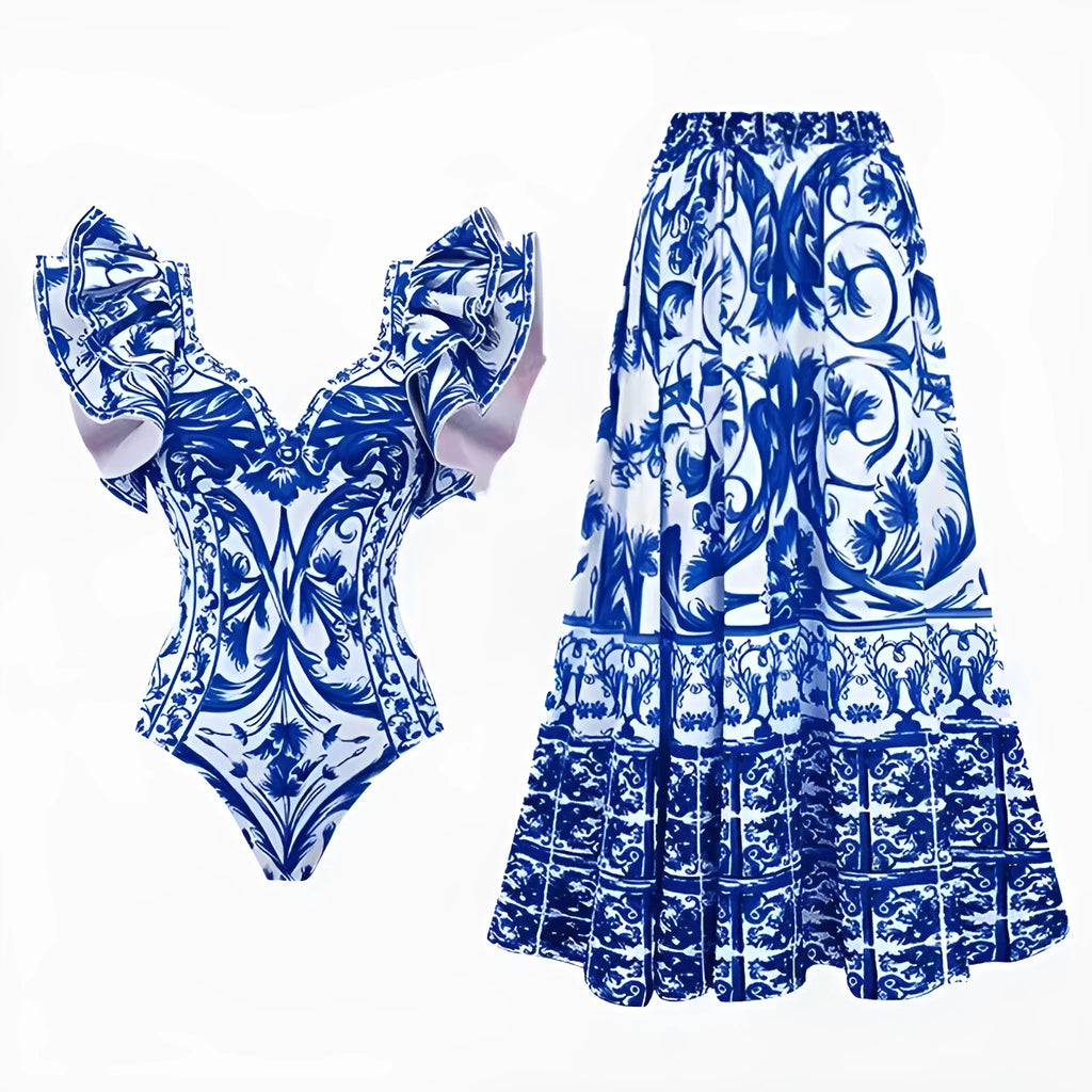 Women's printed one-piece swimsuit set with a matching cover-up skirt on a blue background.