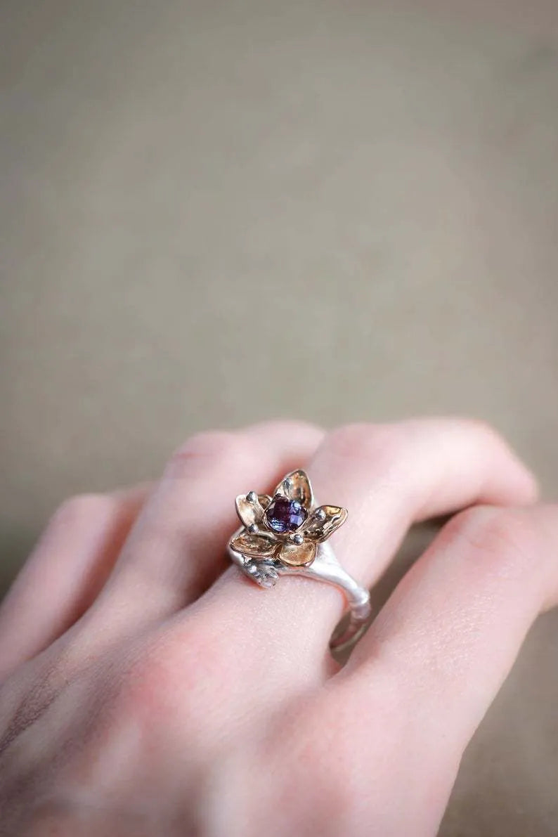 Silver two-tone women's alloy ring with a geometric floral design on a plain background.