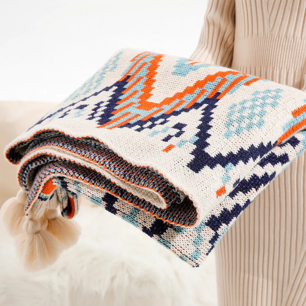 Bohemian style acrylic sofa cover blanket with tassel trim in a geometric pattern colour option.