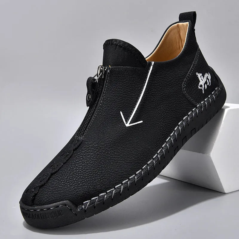 Men's brown leather-look zip-up ankle boots with hand-stitched detailing on a white background.