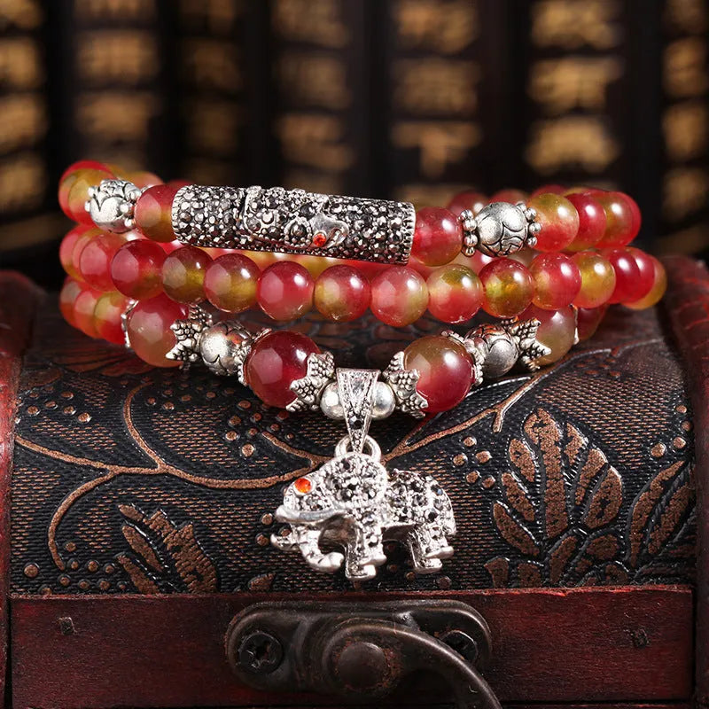 Handmade bracelet with geometric watermelon crystal beads and a Chinese knot closure.