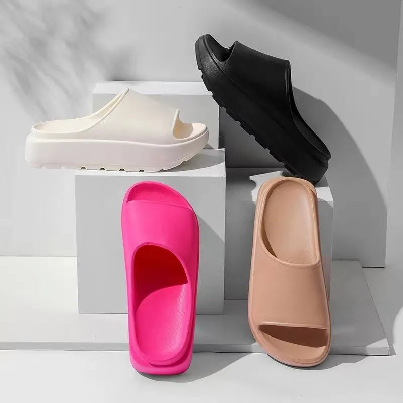 Women's beige fish mouth style slippers with a thick EVA sole on a wooden floor.