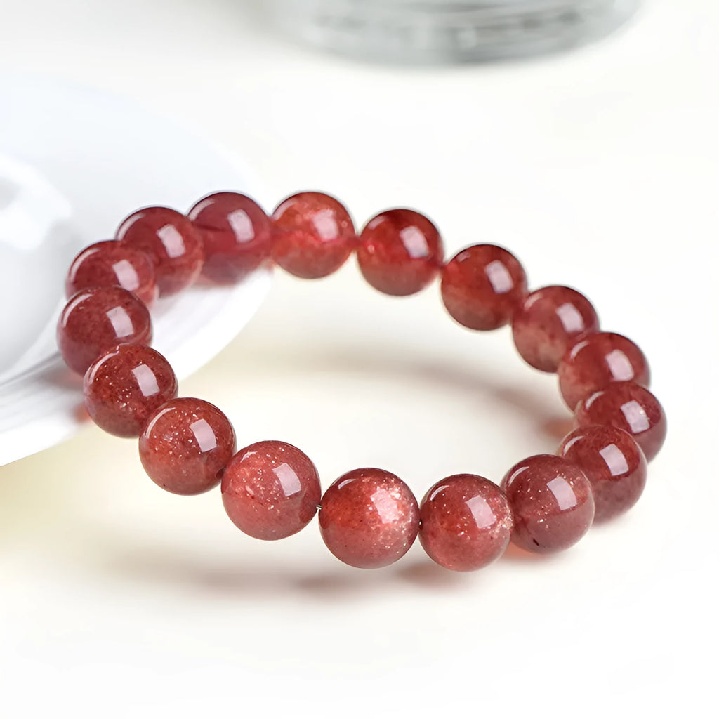Natural cherry red strawberry quartz bracelet with geometric beads on a wrist