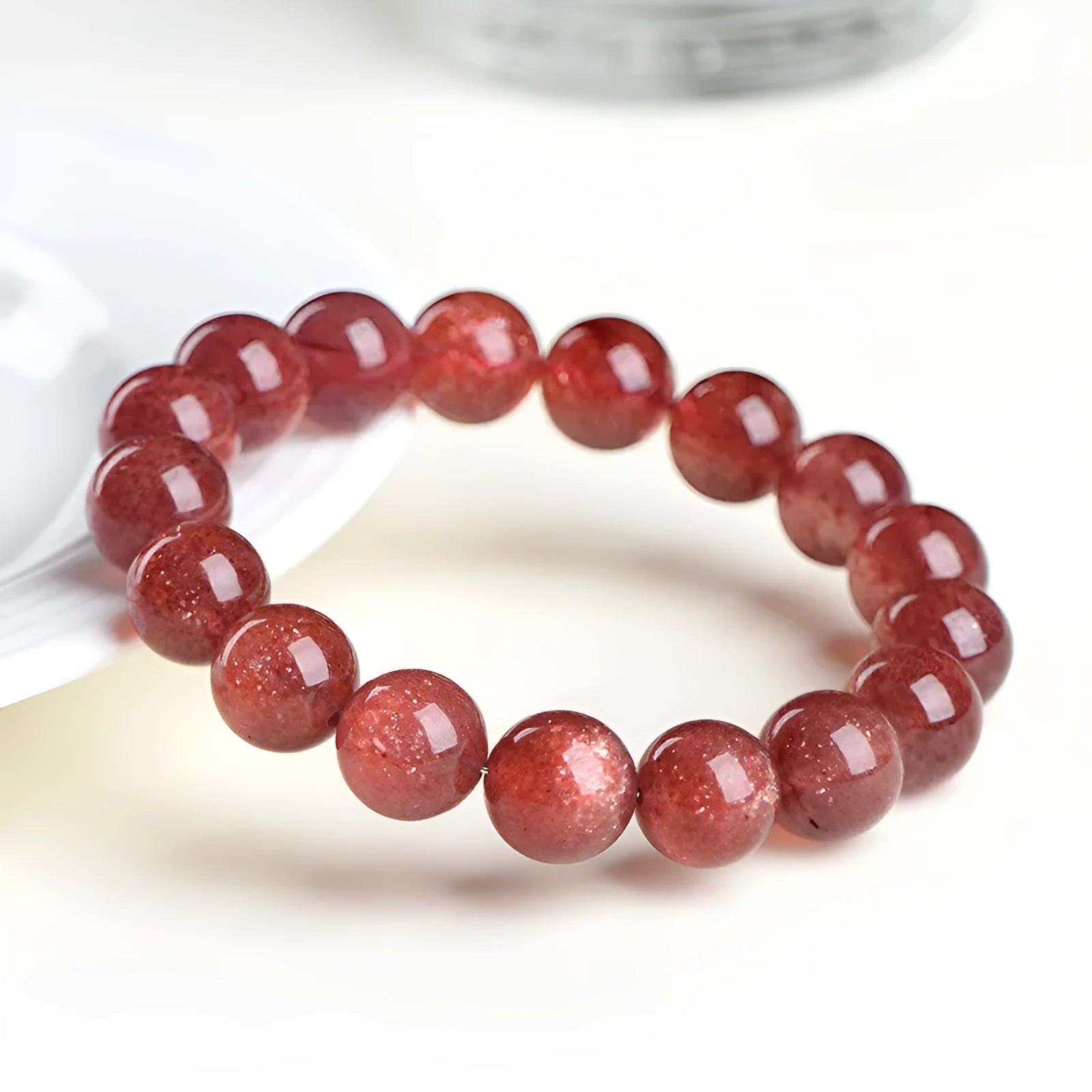 Natural cherry red strawberry quartz bracelet with geometric beads on a wrist