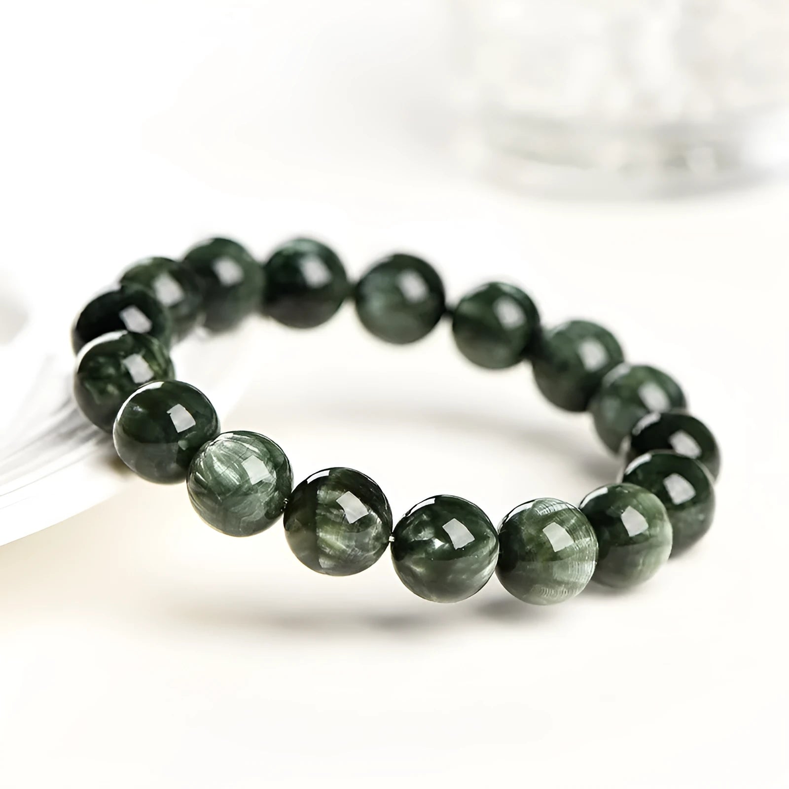 Natural green dragon crystal round bead bracelet with ruyi detail on a white background.