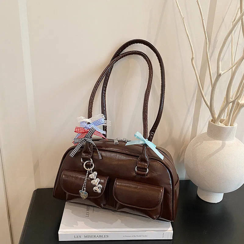 Retro brown PU leather women's pillow-shaped handbag with double shoulder strap and flap closure.