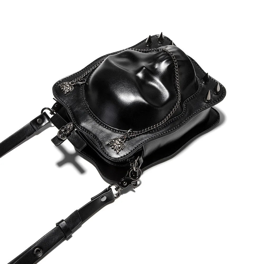 Black vertical square PU leather crossbody bag with embossed skull design, stitching, rivets, and a chain strap.
