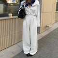 White striped loose fit wide-leg casual trousers with a zipper, shown on a hanger.