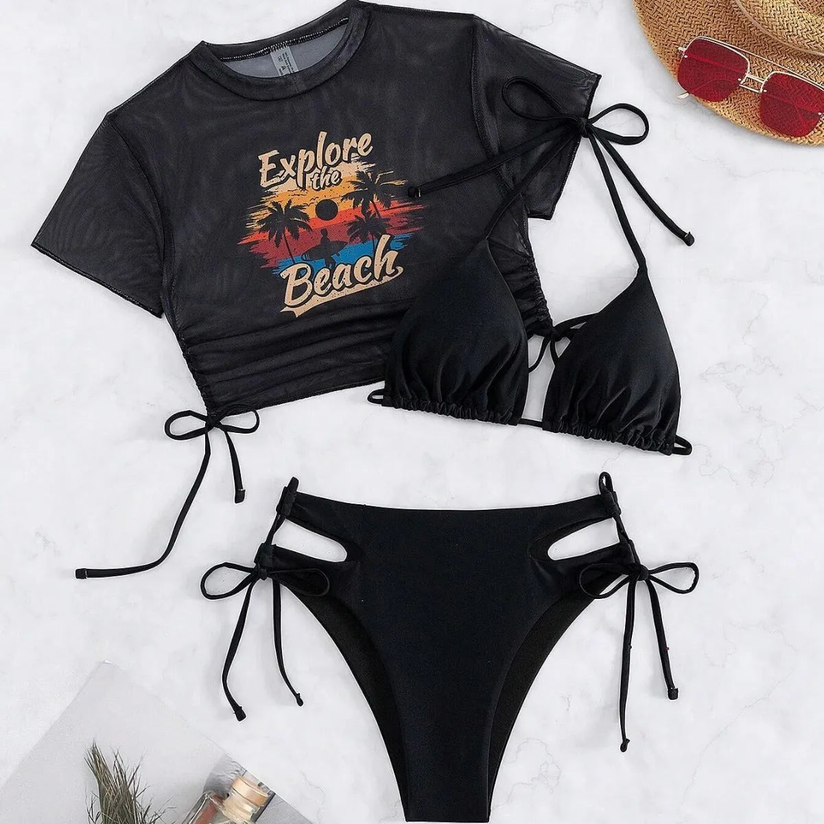 Women's three-piece bikini swimsuit set in black, showing short-sleeved top and pants.