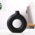 Frosted unglazed porcelain biscuit vase in a simple modern style on a table.