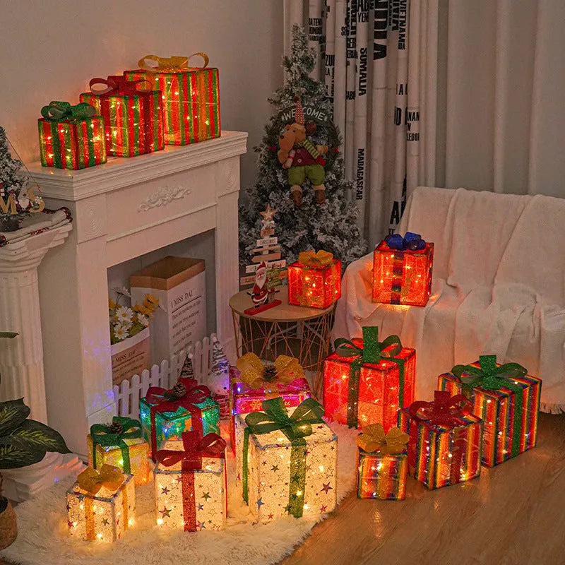 Set of three pre-lit Christmas gift box decorations with bows and LED lights for outdoor use.