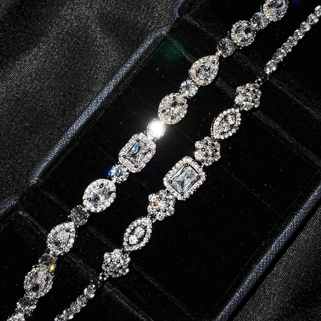 Women's geometric silver bracelet with zircon stones on a white background.