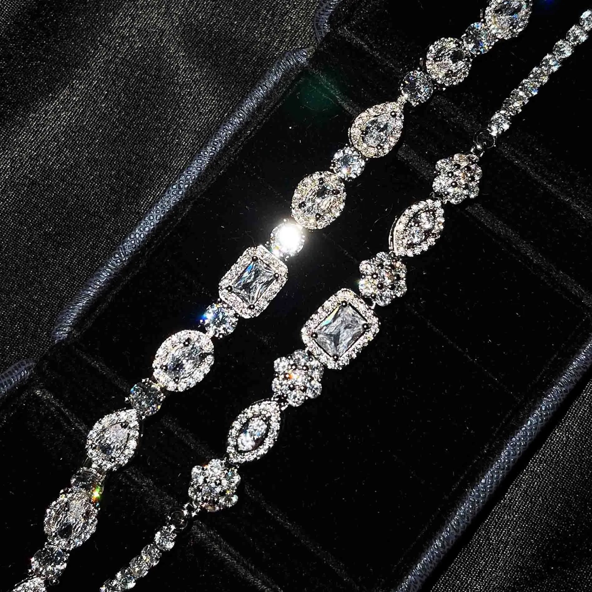 Women's geometric silver bracelet with zircon stones on a white background.