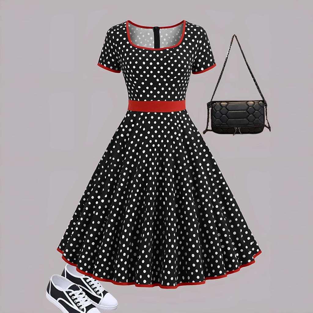 A women's polka dot pleated dress with a square collar and zip closure.