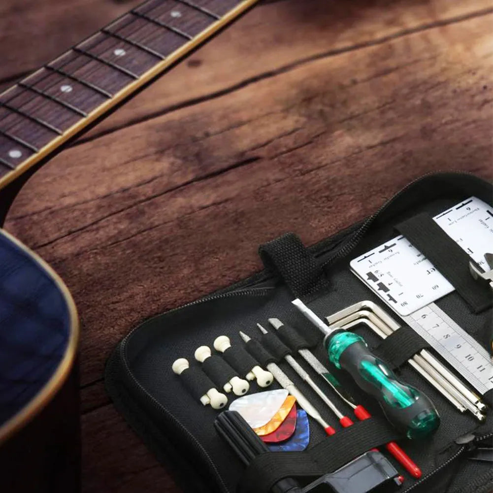 Black guitar repair tool kit open to show tools, next to an acoustic guitar.