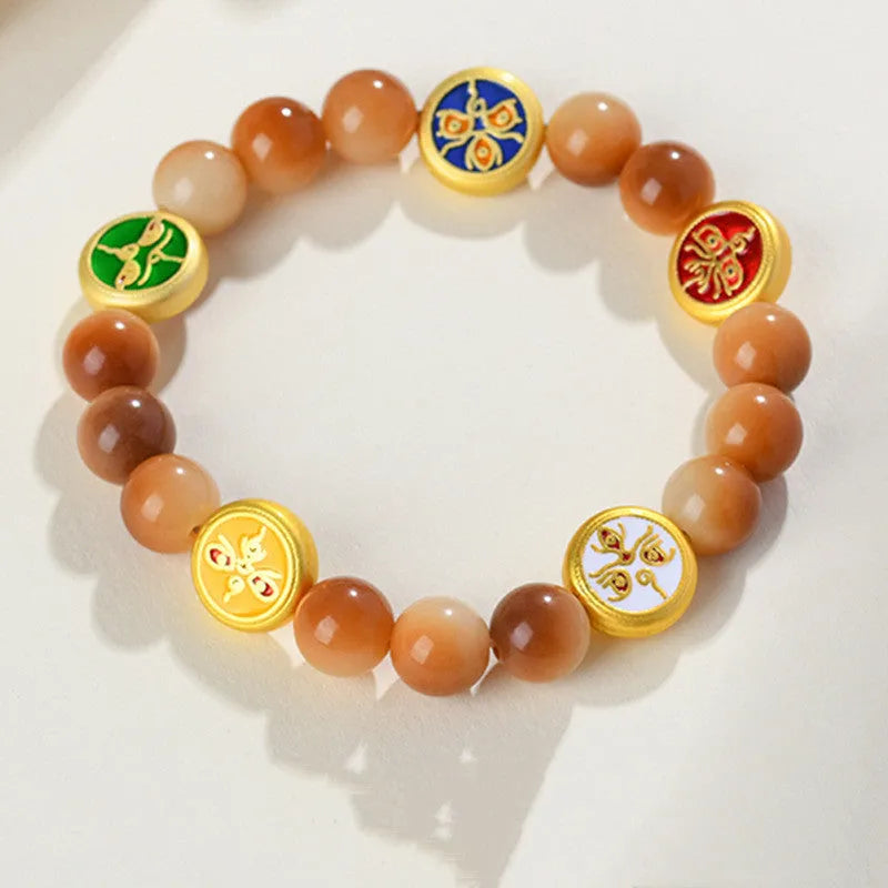Yellow Bodhi seed bracelet with five directions geometry pattern on wooden surface