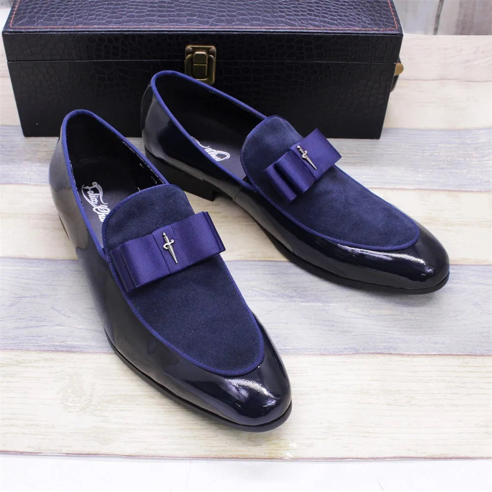 Men's glossy black patent leather low-top shoes featuring a gold tassel detail on a white background.
