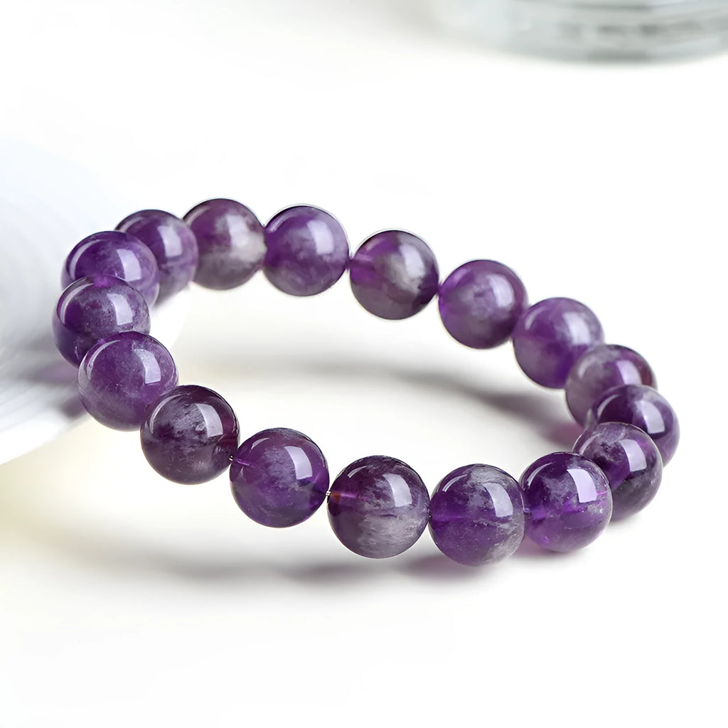 Natural purple feather amethyst crystal bracelet with geometric design and Ruyi element on wrist.