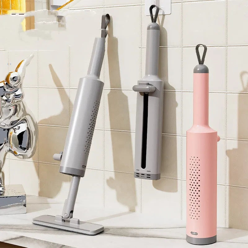 Pink rotatable self-squeeze flat mop with microfiber pad extended on a floor.