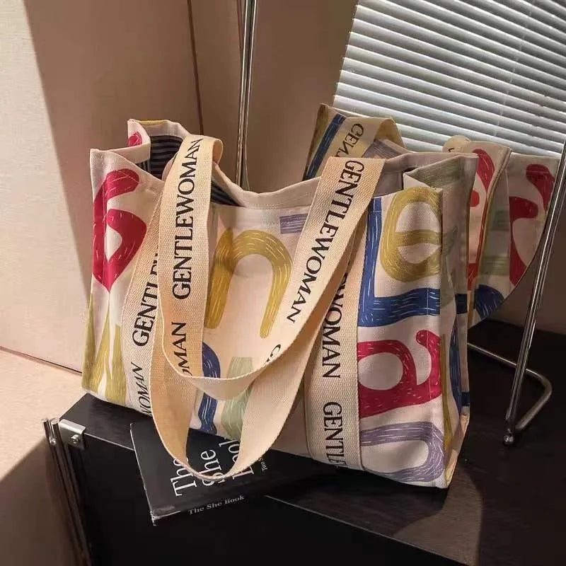 Canvas tote bag with printed design, available in black letters, coloured letters, and pattern style options.