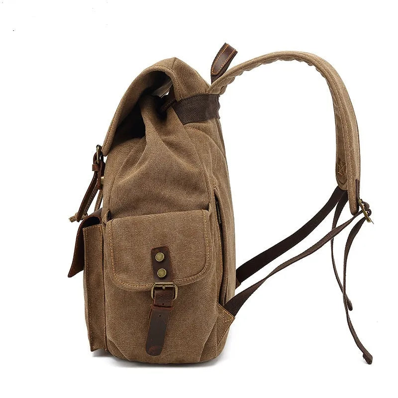 Retro canvas backpack in khaki colour with antique bronze hardware, showing front compartments and straps.