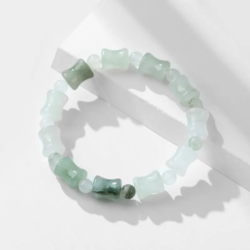 Natural jade and coconut shell beaded bracelet with safety lock clasp on wrist.