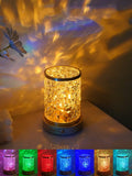 Compact rotating water ripple effect LED night light with solid wood base on a bedside table.