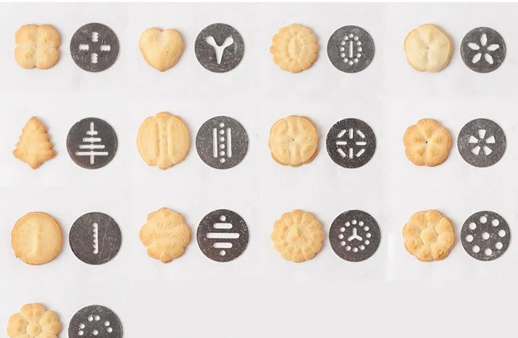 Stainless steel biscuit press gun with set of cookie moulds and piping nozzles on baking tray