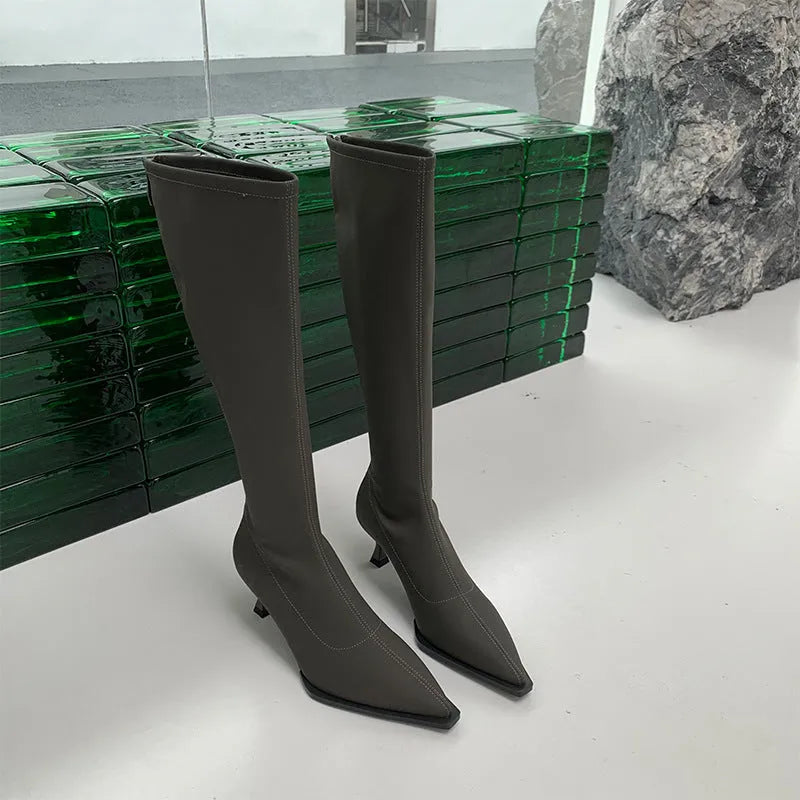 Black pointed toe women's boots with stiletto heel and back zipper, shown from the side.
