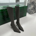 Black pointed toe women's boots with stiletto heel and back zipper, shown from the side.