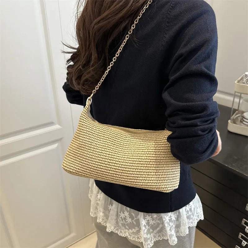 Khaki straw woven horizontal square tote bag with shoulder straps and outer sandwich pocket.