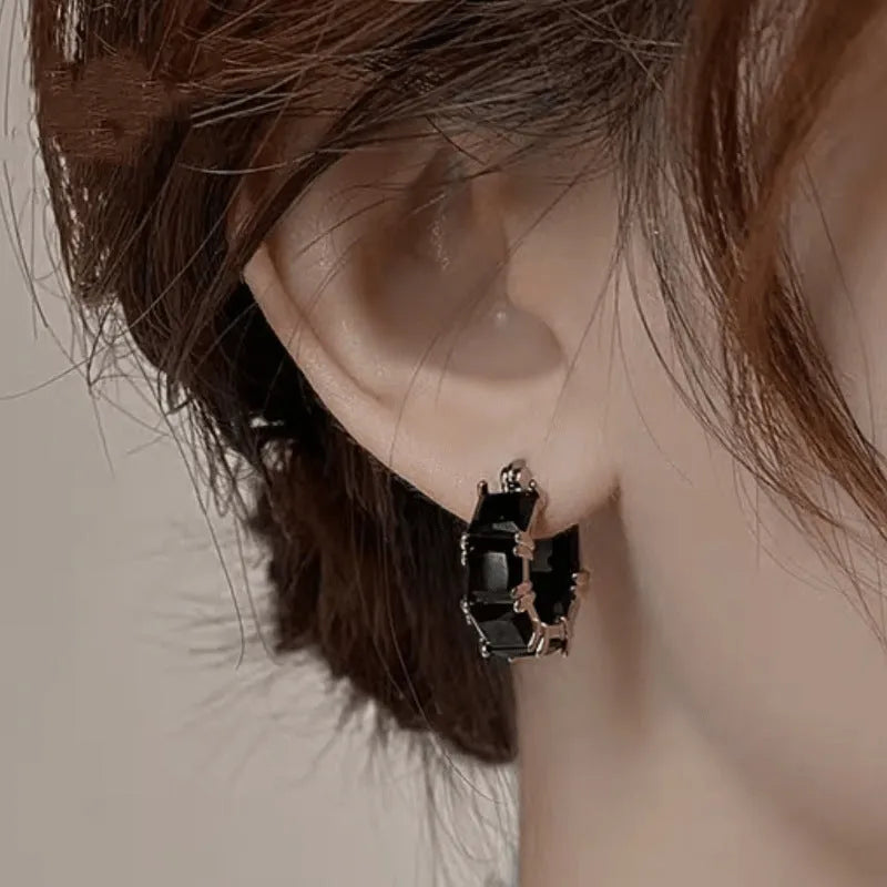 Geometric U-shaped gold earrings with black crystal zirconium stones in round design