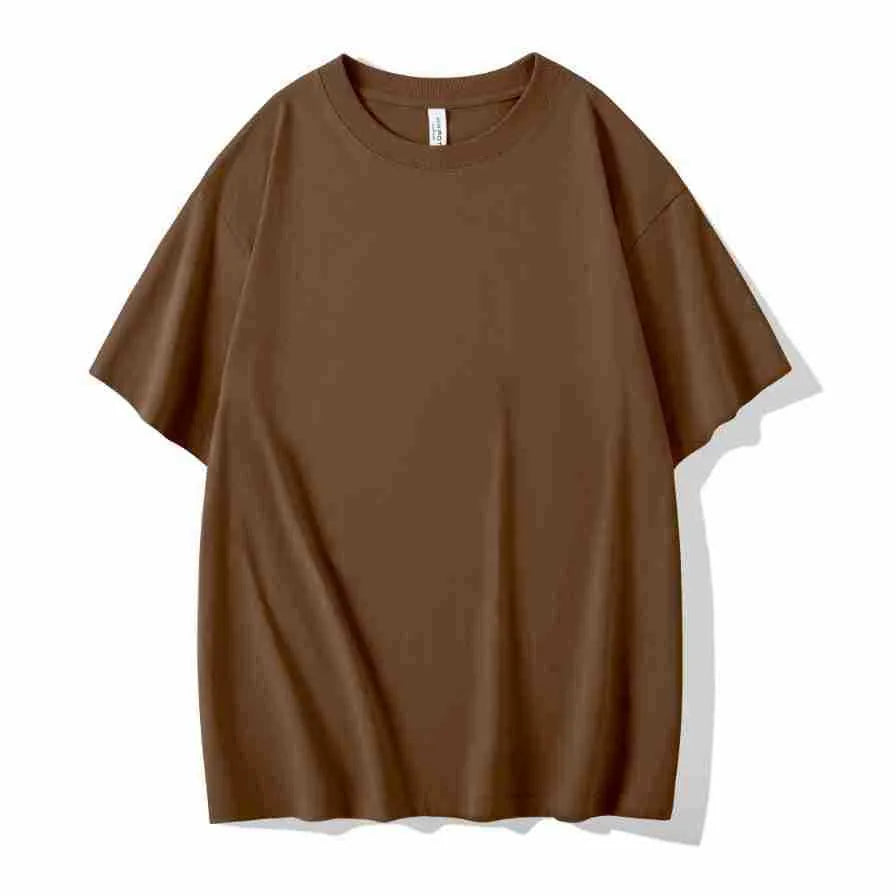 Man wearing a heavyweight dark grey drop shoulder T-shirt with layered shoulder detail.