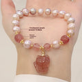 Women's light pink freshwater pearl bracelet with a small fox charm on a natural background.