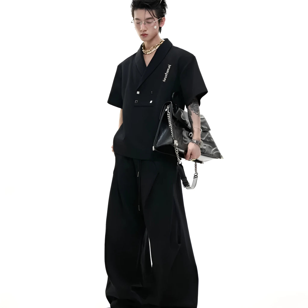Men's dark grey cotton sports suit with V-neck jacket, padded shoulders, metal embellishments, and matching shorts.