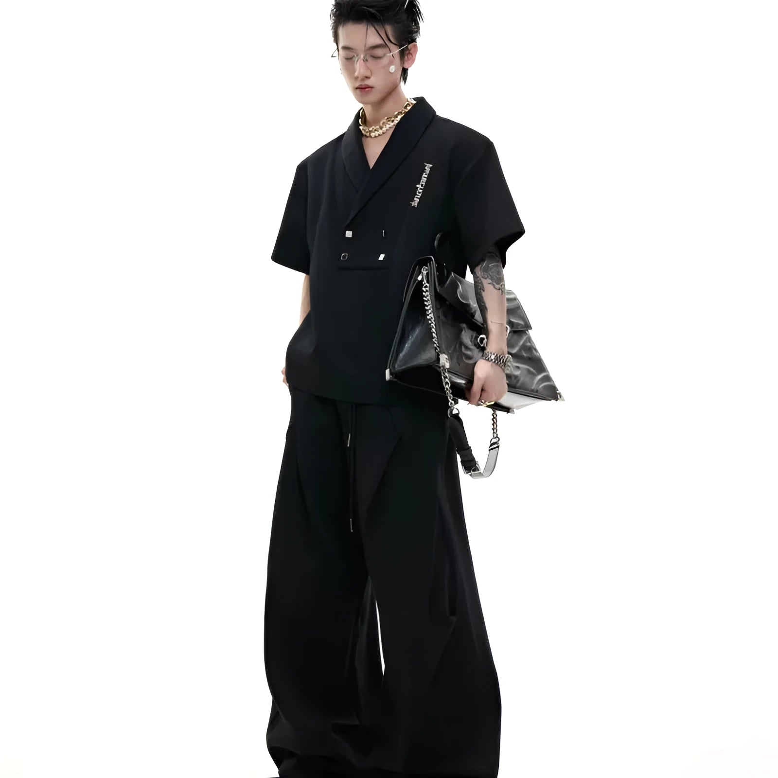 Men's dark grey cotton sports suit with V-neck jacket, padded shoulders, metal embellishments, and matching shorts.