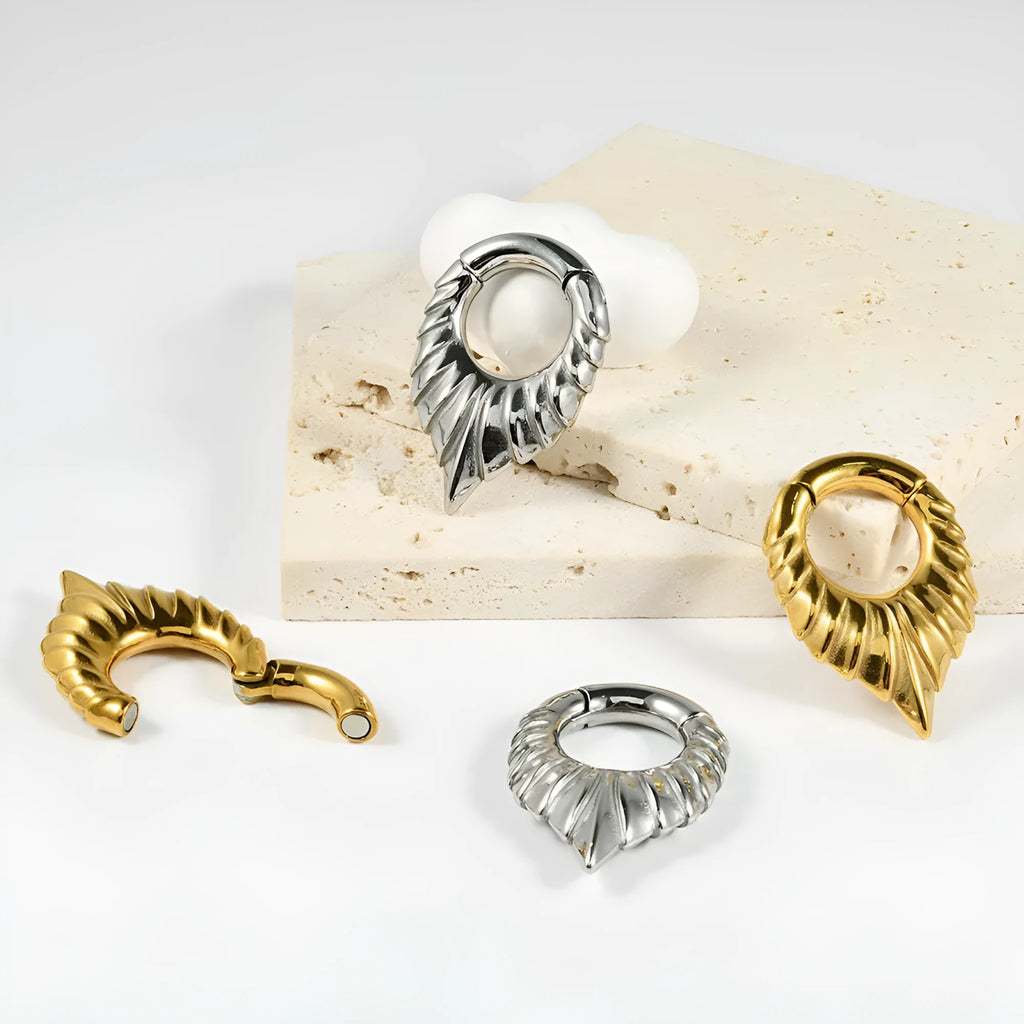Stainless steel ear extender with egg-shaped auricle and totem design for earlobe stretching.