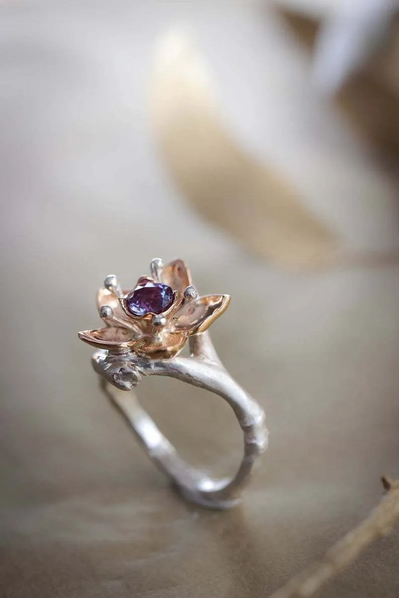 Silver two-tone women's alloy ring with a geometric floral design on a plain background.