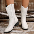 Black women's mid-calf Martin boots with a chunky heel, pointed toe, and hollow-out details.