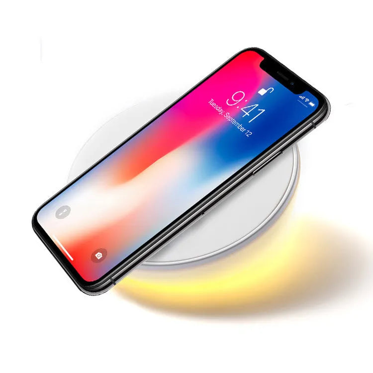 White wireless charging pad with clock display and control buttons for smartphone charging