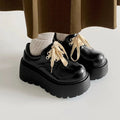 Matte black women's lace-up shoes with a high English muffin heel and thick rubber sole.