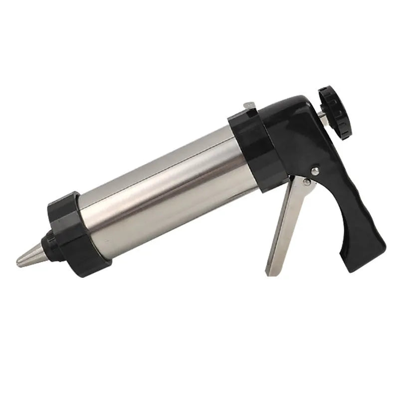 Stainless steel biscuit press gun with set of cookie moulds and piping nozzles on baking tray