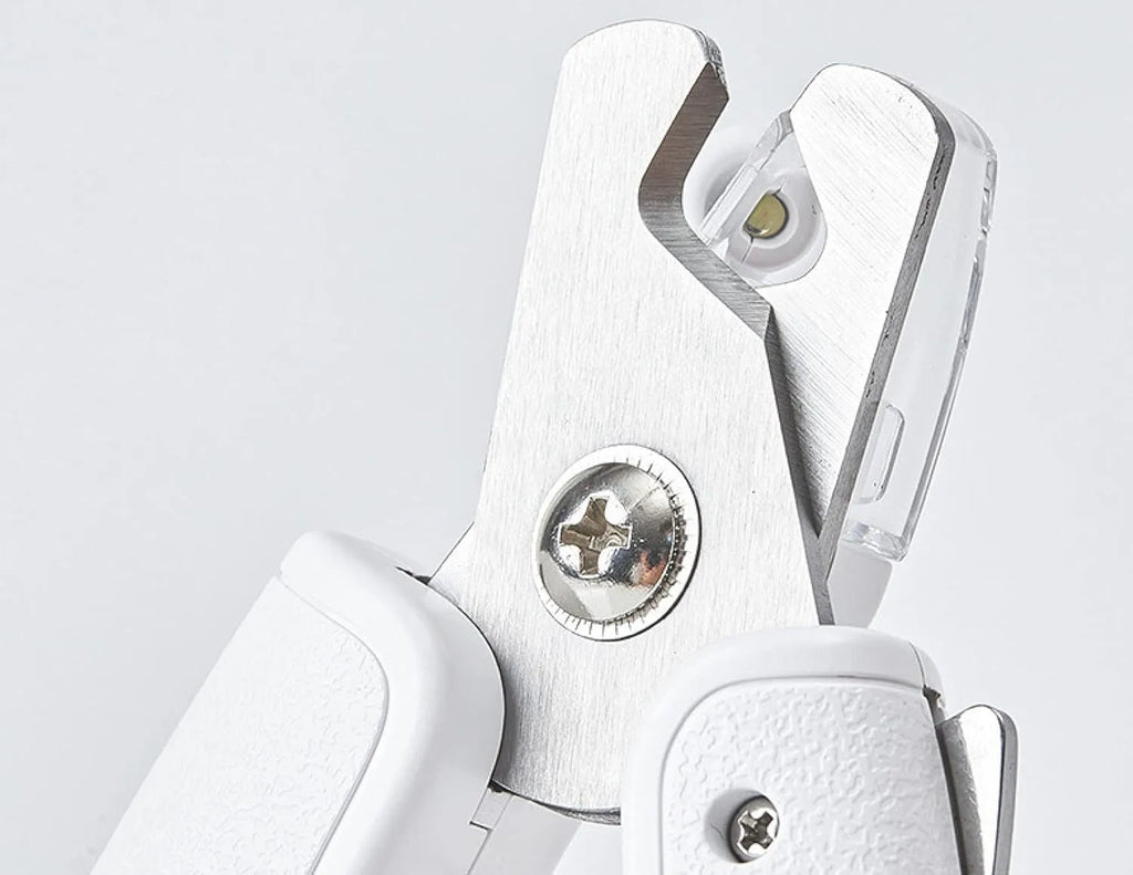White LED pet nail clippers with a transparent guard open, showing the triangular blade and integrated nail file.