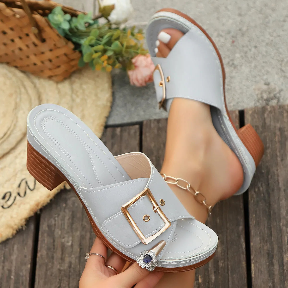 Women's black chunky heel slippers with a silver metal buckle and a round toe.