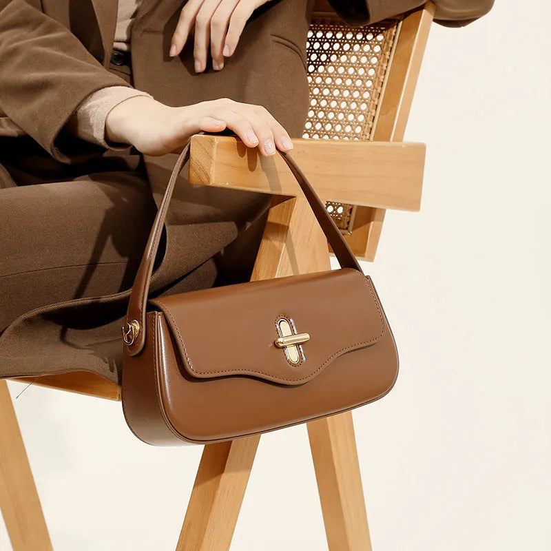 Genuine leather baguette handbag in caramel colour with clamshell design and shoulder straps