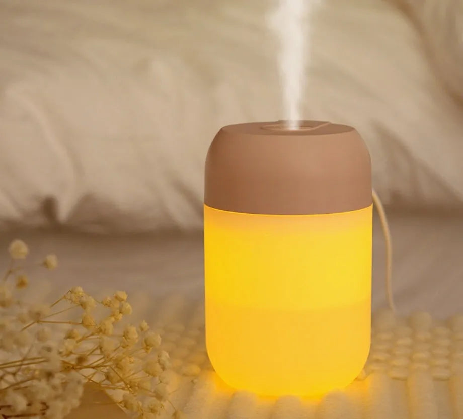 White cylindrical USB mini humidifier with mist output and charging cable