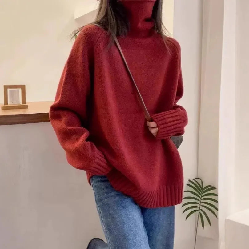 A woman wearing a loose red turtleneck sweater with a thick, curling pile collar.