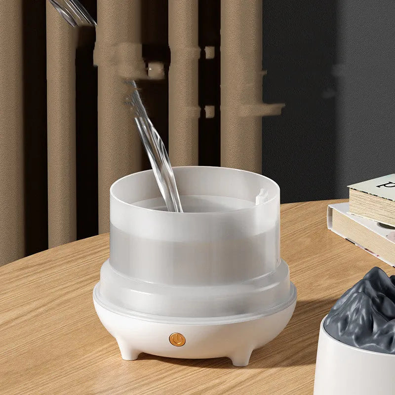 White volcano-shaped humidifier and aromatherapy diffuser on a table with USB cable.