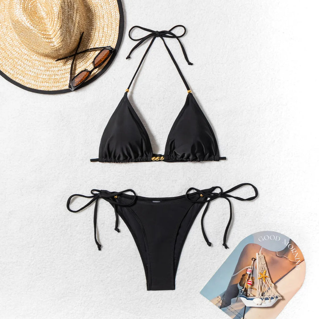 Black women's bikini swimsuit with metal bead detail and split-front design